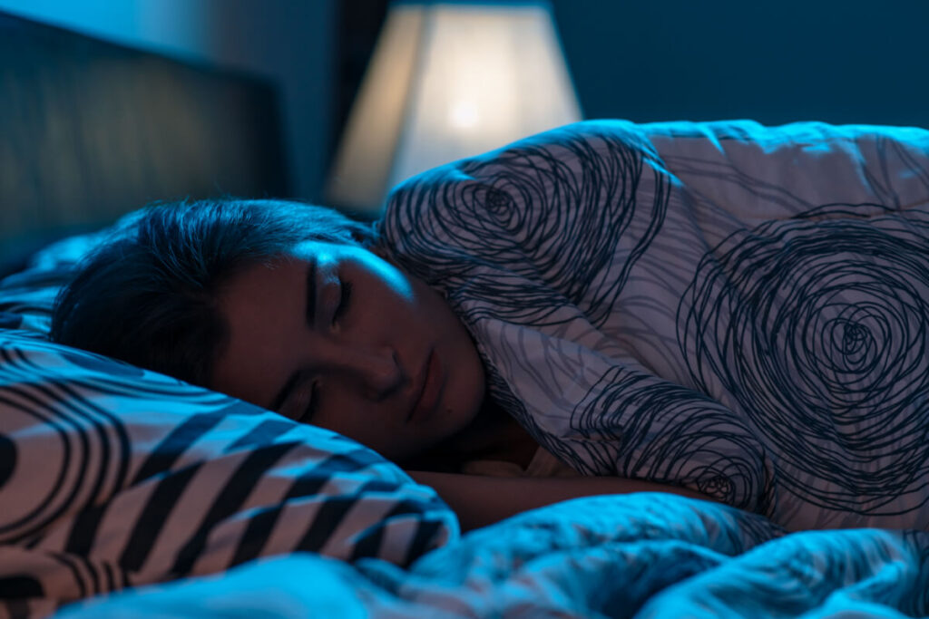 Młoda kobieta śpi. Jak hormony wpływają na zdrowie