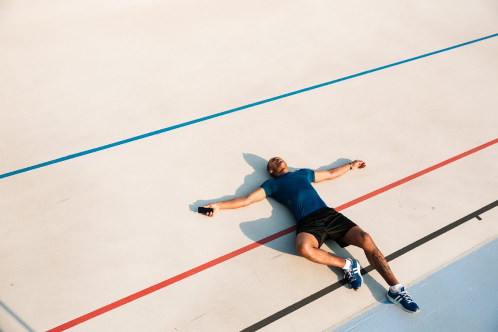 Wyczerpany treningiem biegacz na bieżni. Uzależnienie od ćwiczeń - jak je rozpoznać