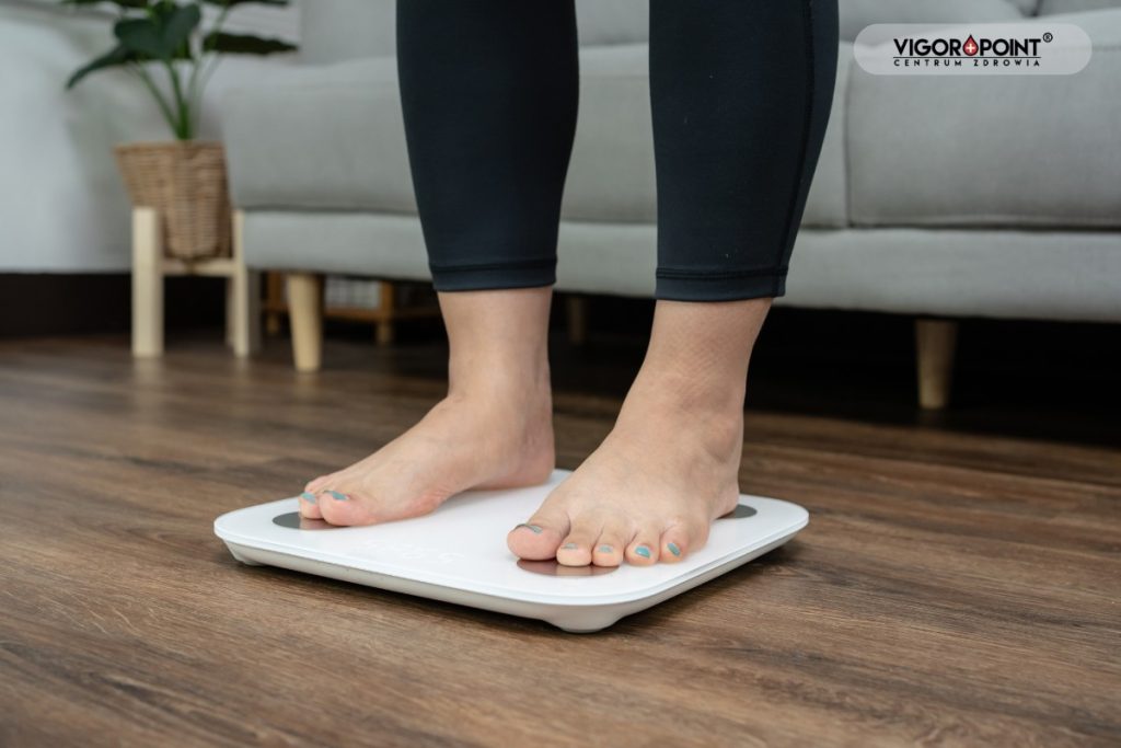 Kobieta na wadze łazienkowej. Dlaczego waga stoi w miejscu mimo diety?