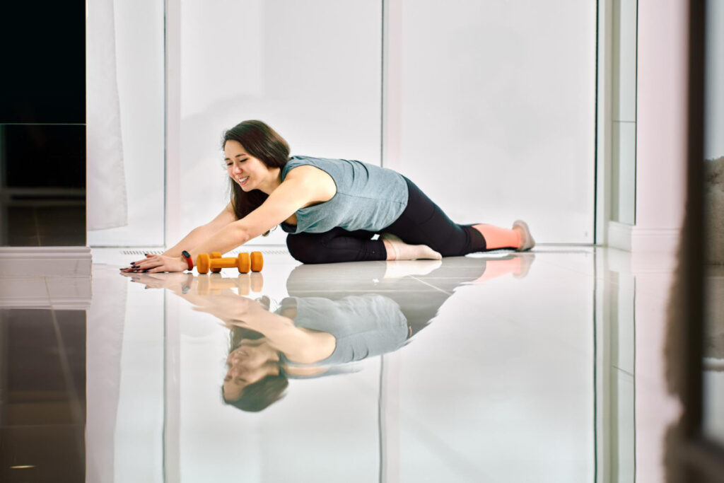 Kobieta z nadwagą ćwiczy na podłodze