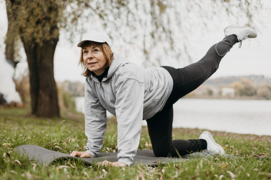 Kobieta w parku ćwiczy na macie. dbać o prawidłową masę ciała 
